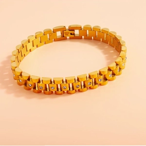 Macro shot of gold stainless steel watch-style bracelet with pavé crystal settings