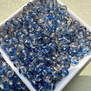 Vue macro de perles en verre bleues de 6mm dans un plateau pour bijoux faits main DIY