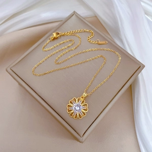Macro detail of gold flower pendant with sparkling crystals on jewelry box