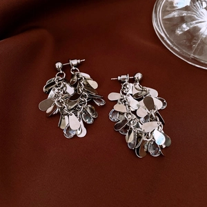 Detailed shot of silver waterdrop tassel earrings with clear crystals on fabric