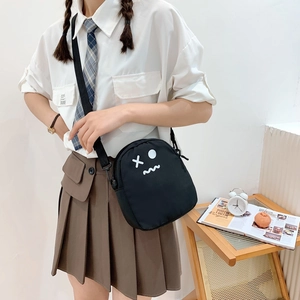 Sac bandoulière en toile noire de style japonais avec visage cartoon et tenue scolaire