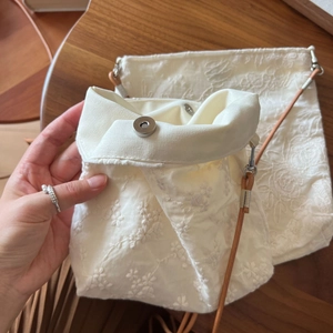Detailed embroidery and magnetic snap closure on beige cotton linen crossbody phone bag