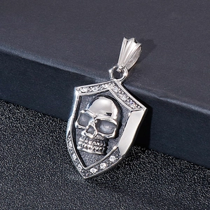 Vintage silver shield pendant featuring a skull with anchor design and sparkling stones