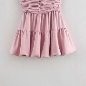 Pink satin mini dress with draped ruched balloon skirt design for women in a studio view