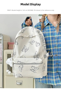 White butterfly print backpack featuring a fluffy cloud charm and zipper front pocket