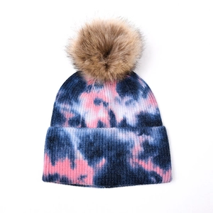Détail du bonnet d'hiver en maille tie-dye avec pompon amovible en fausse fourrure rose et bleu