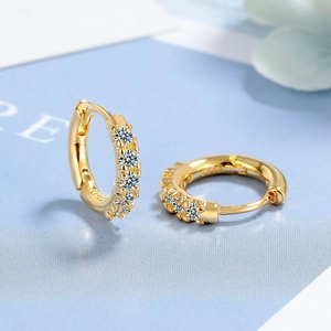 Macro detail of gold hoop earrings with clear cubic zirconia and S925 silver stamp