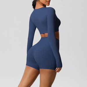Zijaanzicht van donkerblauwe yogaset met crop top met lange mouwen en biker short