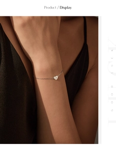 Détail du bracelet coeur en argent S925 avec diamant étincelant sur le poignet d'une femme