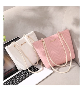 Detail of V-quilted texture and rope handle on stylish tote bags in white and pink