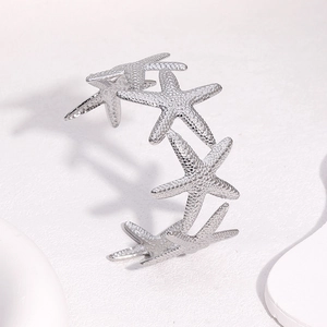 Dettaglio dei bracciali in argento a forma di stella marina su espositore moderno