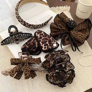 Leopard print hair accessories collection with shark clips on a vintage lifestyle setting