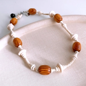 Detail of wooden beads and textured cream discs on a vintage ethnic style necklace
