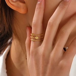 Three-layer gold stainless steel ring with moon and sun charms worn by a model