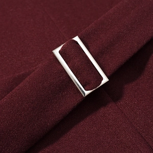 Detail of burgundy wool coat belt with polished silver square metal buckle closure