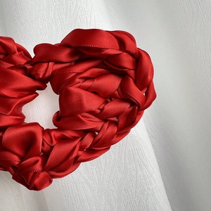 Chouchou cœur élégant en satin rouge tissé sur fond de tissu blanc pour femme