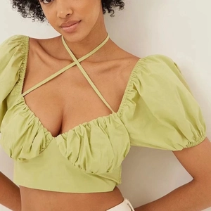 Light green cropped puff sleeve top with backless lace-up design and pleated front