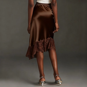 Detail of brown satin skirt with irregular lace hem showing delicate fabric texture