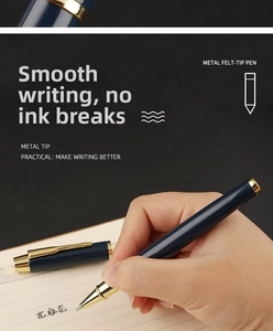 Detail of blue metal rollerball pen writing smoothly on paper with a gold clip