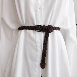 Close-up of dark coffee braided waist belt texture with vintage metallic pin buckle