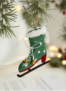Detail eines grünen Schlittschuh-Weihnachtsanhängers mit Glocken am Tannenbaumzweig
