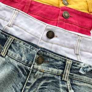 Dettaglio della vita di pantaloncini di jeans a vita bassa in quattro colori diversi