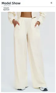 Detail of creamy apricot wide-leg sports pants with elastic waist and side pockets