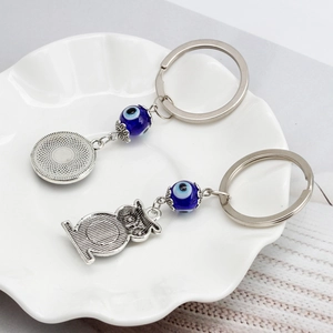 Portachiavi con malocchio blu con gufo e ciondolo tondo su un piatto bianco
