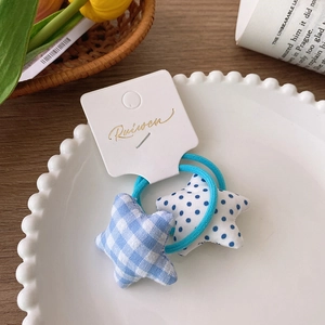 Close-up of starry fabric hair ties with blue plaid and polka dot patterns on display