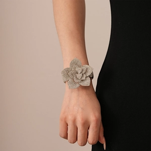 Detail of silver geometric flower cuff bracelet with rhinestones worn by a model