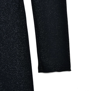 Macro shot of sparkling black fabric texture on long sleeve jumpsuit with shimmery sequins