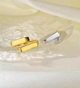Macro detail of gold and silver S925 sterling silver cross rings on a glass plate