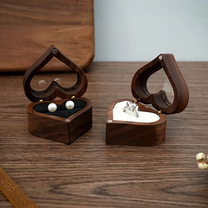 Detail of heart-shaped walnut wood ring box with clear window and plush velvet lining