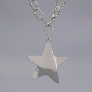 Close-up of polished silver pentagram star pendant on chunky metal oval link chain