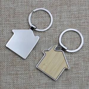 Macro detail of house-shaped metal and wood keychains on rustic burlap fabric background