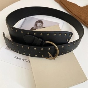 Detail view of the black leather waist belt with double-row bronze rivets and vintage round buckle