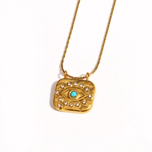 Macro shot of 18k gold plated square pendant with turquoise evil eye and rhinestones
