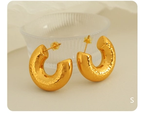 Detailed macro shot of 18K gold plated hoop earrings with irregular hammered texture surface
