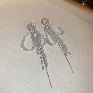 Detailed macro view of long light blue crystal tassel earrings with golden chains