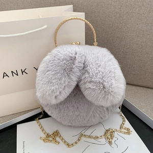 Chic plush round handbag with rabbit fur texture, gold handle, and elegant chain strap