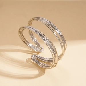 Macro detail of silver geometric layered wire cuff bracelet with a polished metal finish