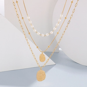 Three-layer gold necklace set featuring faux pearls and irregular circular pendants