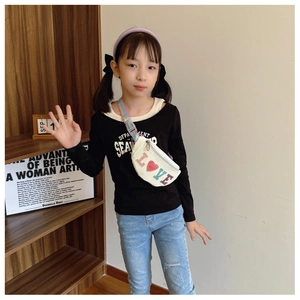 Close-up of beige children's sequin waist bag with rainbow strap on kid model