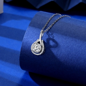 Detail of tear-drop pendant with large round stone and pavé setting on blue display