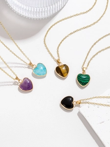 Detail of five heart-shaped natural stone pendants with gold chains in multiple colors