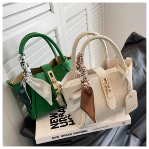 Détail de sacs seaux vert et beige avec foulards décoratifs et fermoirs métalliques