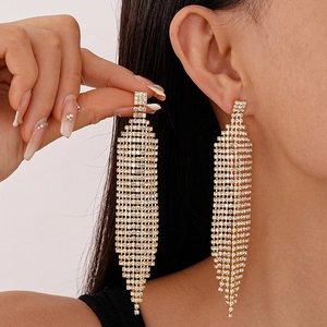 Boucles d'oreilles pendantes géométriques dorées avec strass blancs sur modèle