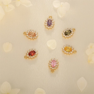 Elegant 18K gold-plated oval pendants with colorful zircon stones on textured background