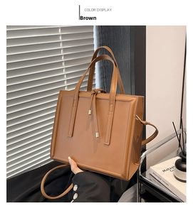 Vista dettagliata di una borsa tote in pelle marrone con cinturini e accenti metallici