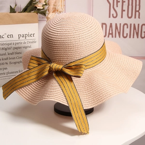 Detailed view of the woven straw sun hat texture and elegant striped ribbon bow detail